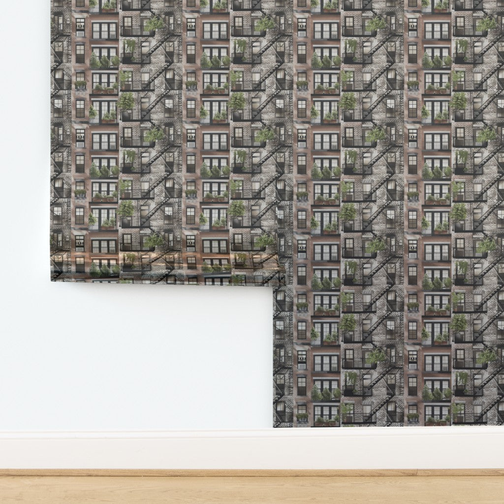 A roll of Garden Fire Escapes wallpaper revealing the intricate green and red illustrations.