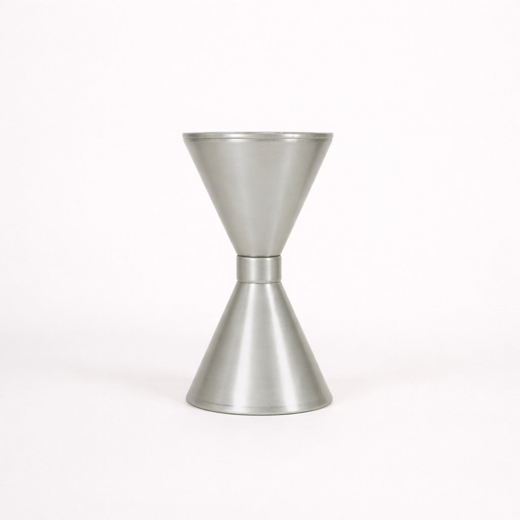Metallic cocktail jigger on a white background