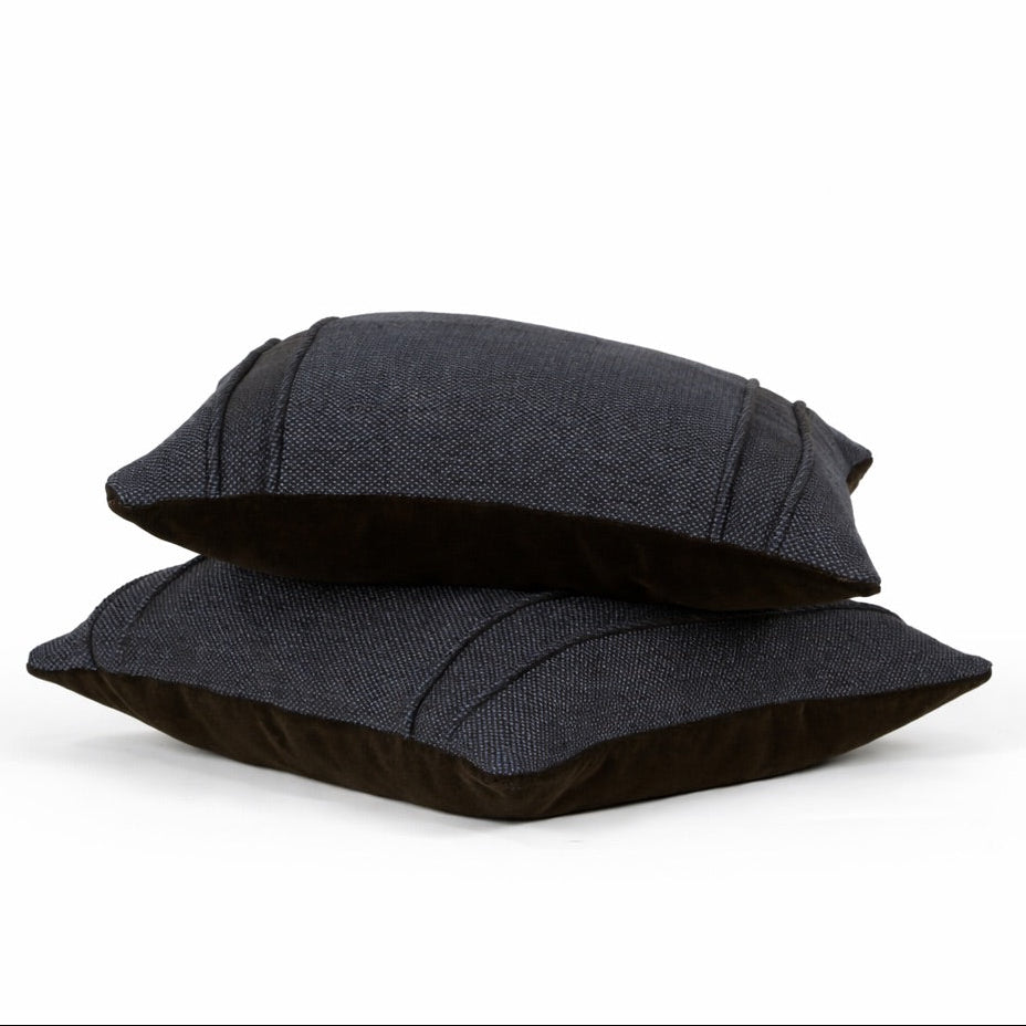 Two black pillows stacked on a white background