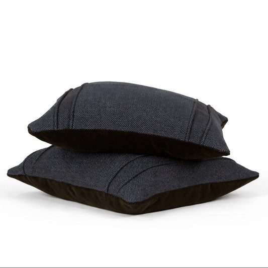 Two black pillows stacked on a white background