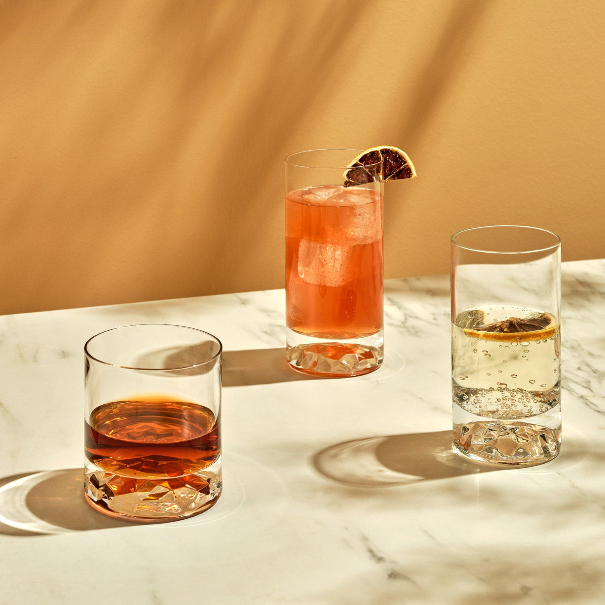 A single NUDE Glass Club highball glass filled with a refreshing cocktail and ice, highlighting the clear crystal design.