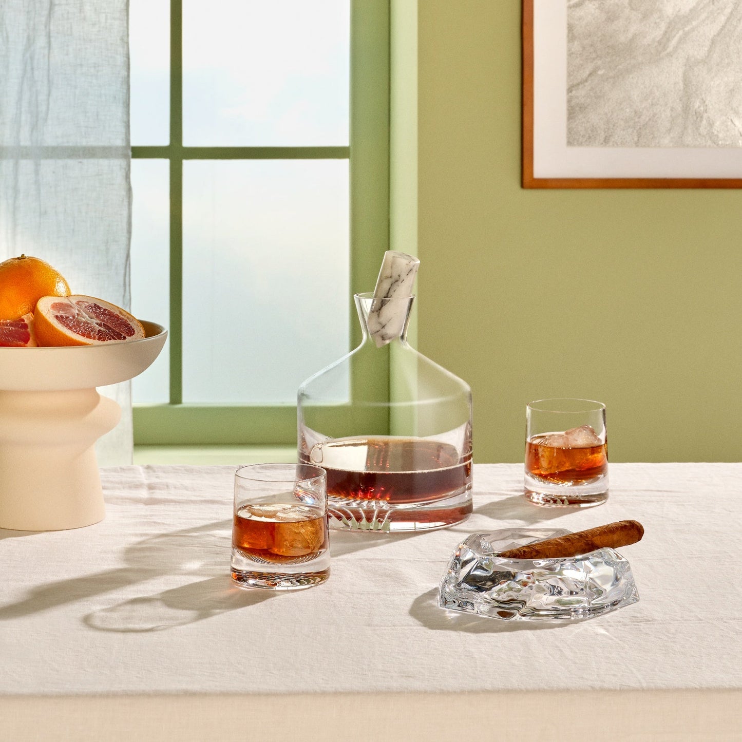 Pouring amber spirits into a heavy-bottomed lead-free crystal tumbler.