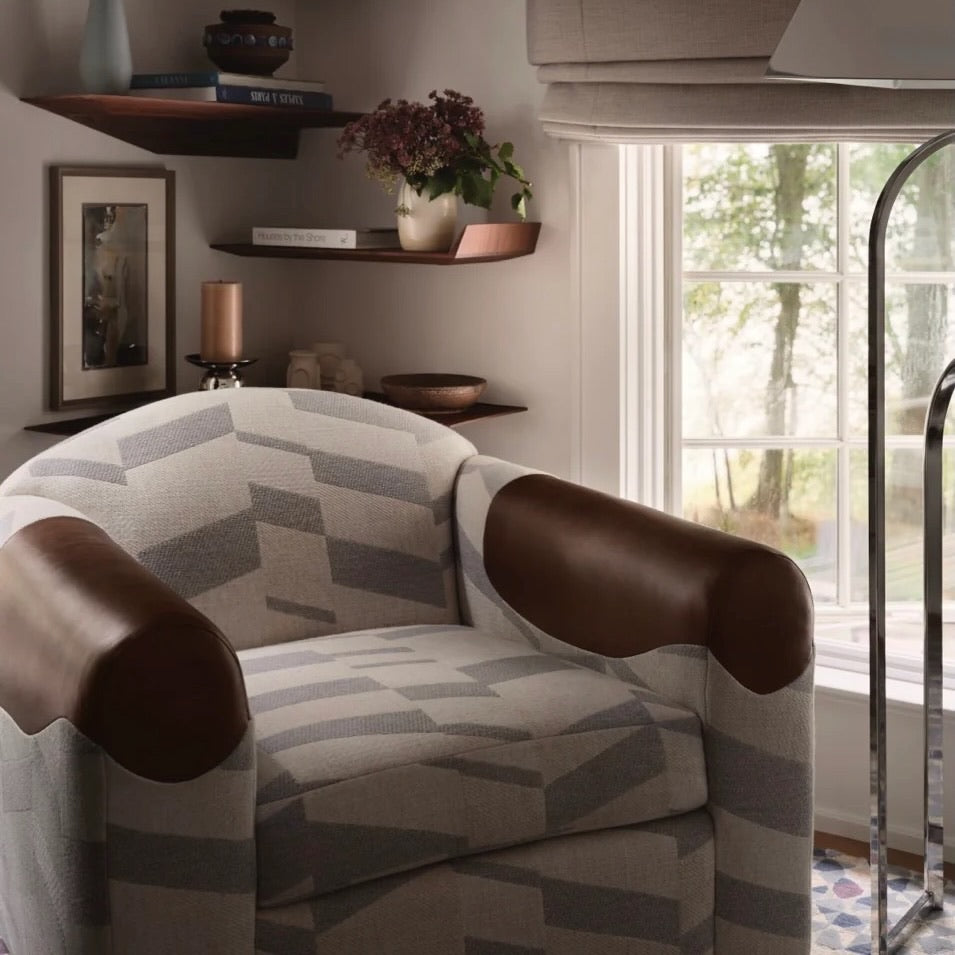 Equestrian-inspired lounge chair featuring taut leather strapping in a curated study