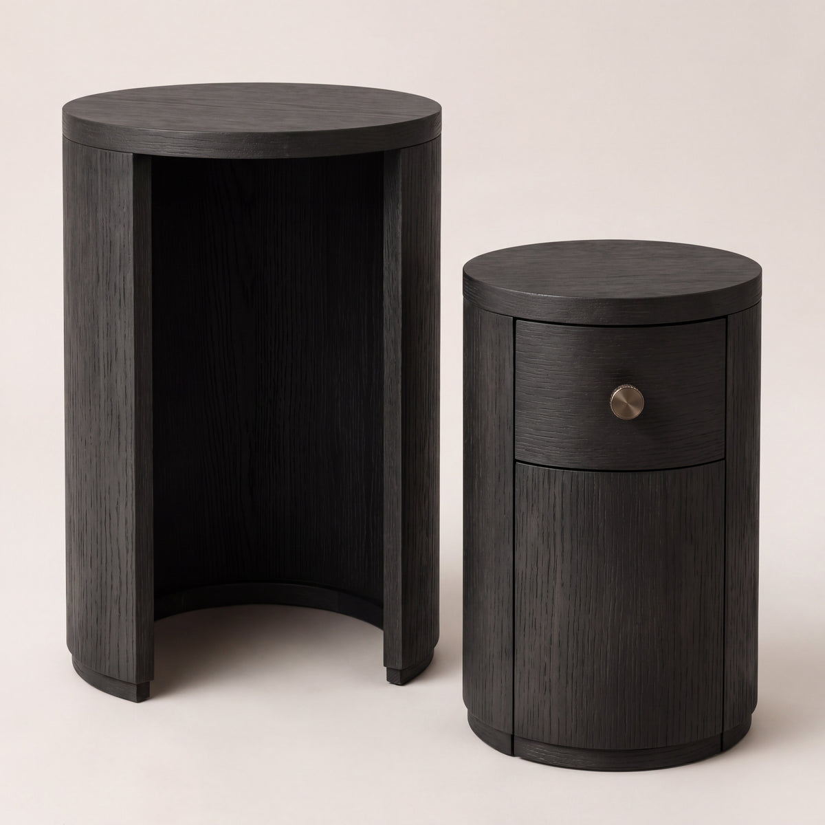 Pair of ebony-finished ash wood nesting tables shown separated.