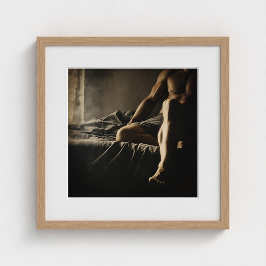 Contemplative Male Figure on Bed in Warm Linen Light