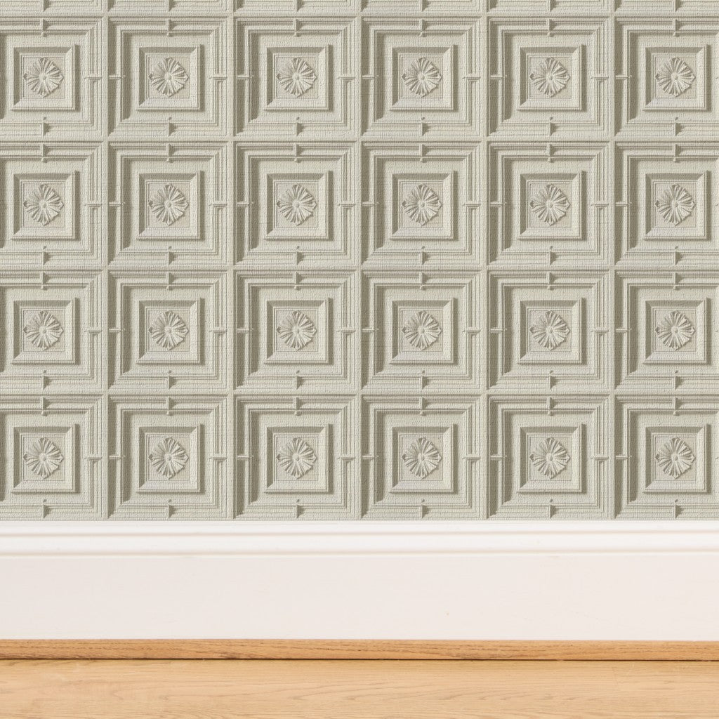 Detailed close-up of the dimensional plasterwork pattern on ivory medallion wallpaper.