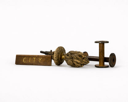 Vintage-style wooden spool with decorative element and 'CITY' label on a white background