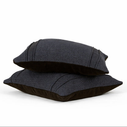 Two black pillows stacked on a white background