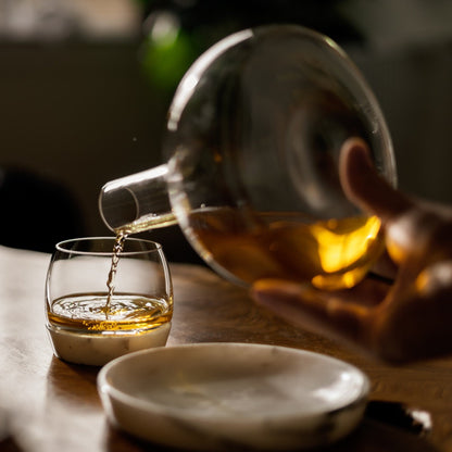 Pouring amber spirits from a Chill carafe into the matching marble-based glass.