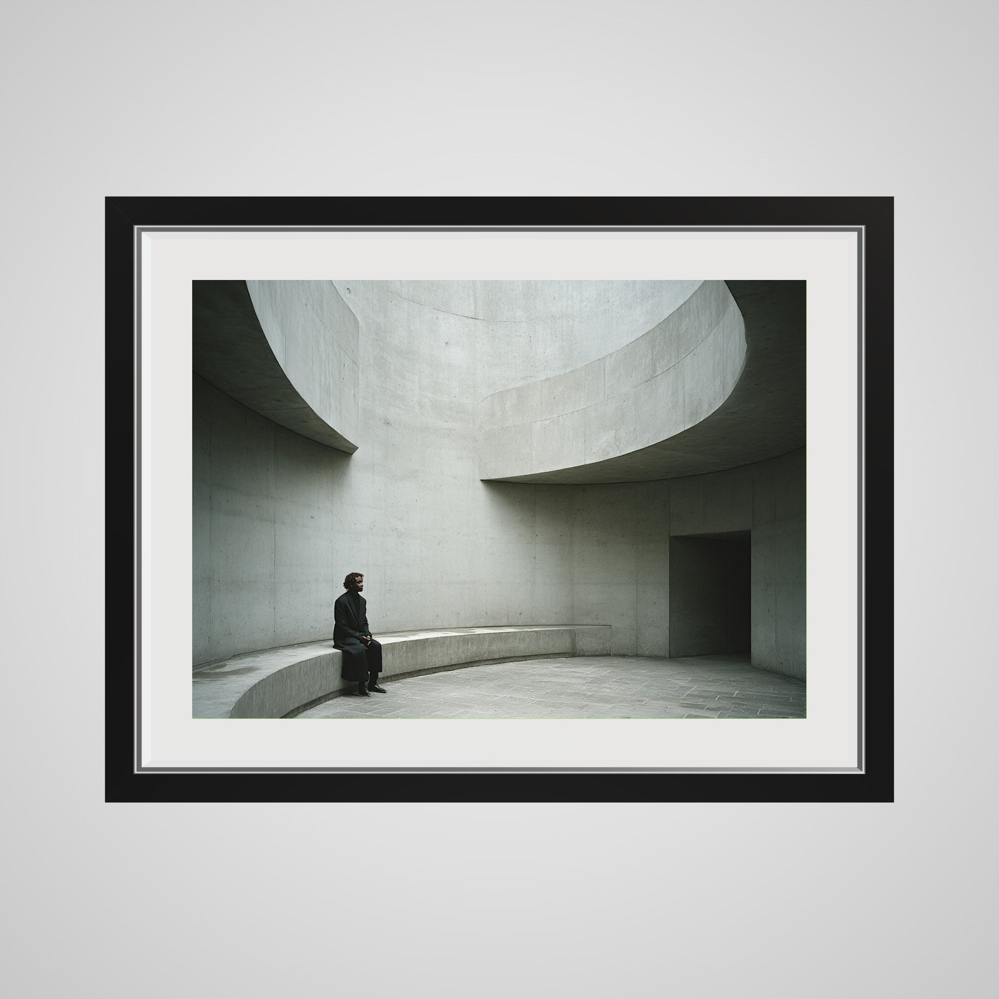 Front view of Solitary Figure on Concrete Bench print in a 24x18 deep black spacer frame