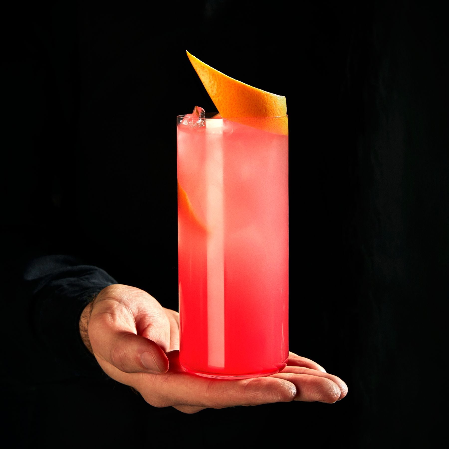 A styled lifestyle scene featuring a Finesse highball glass filled with a refreshing beverage on a modern table.