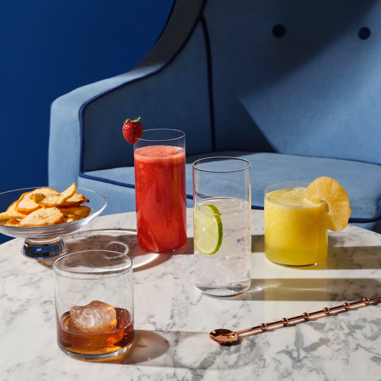 Elegant modern table setting with Finesse highball and whisky glasses, a silhouette bowl, and refined bar accessories.