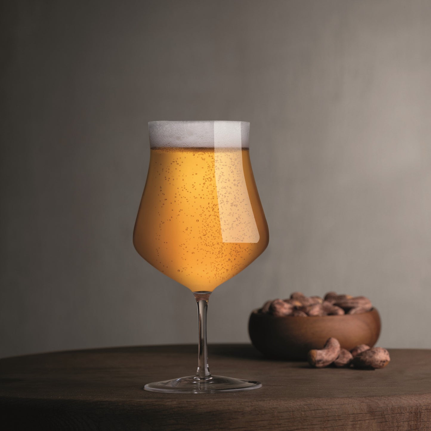 Close-up of a single NUDE Glass Islands crystal beer glass showing its elegant tapered base.