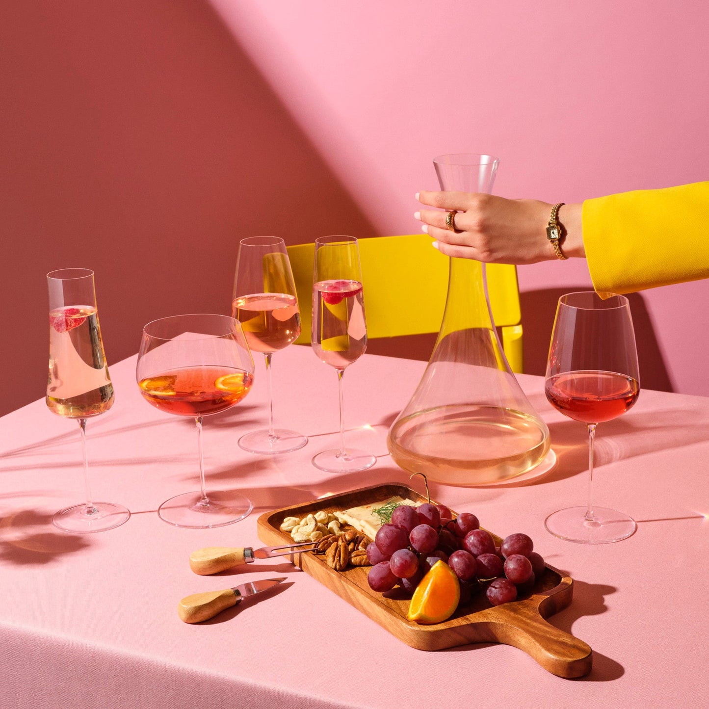 A curated collection of modern NUDE glassware, including a crystal decanter and champagne flutes.