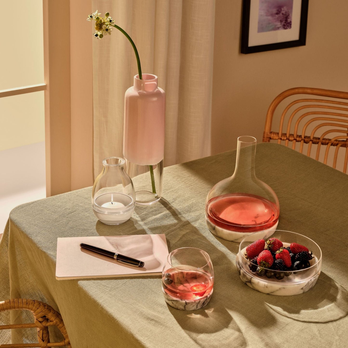Contemporary dining table display featuring a glass vase, elegant candle holder, and crystal carafes.