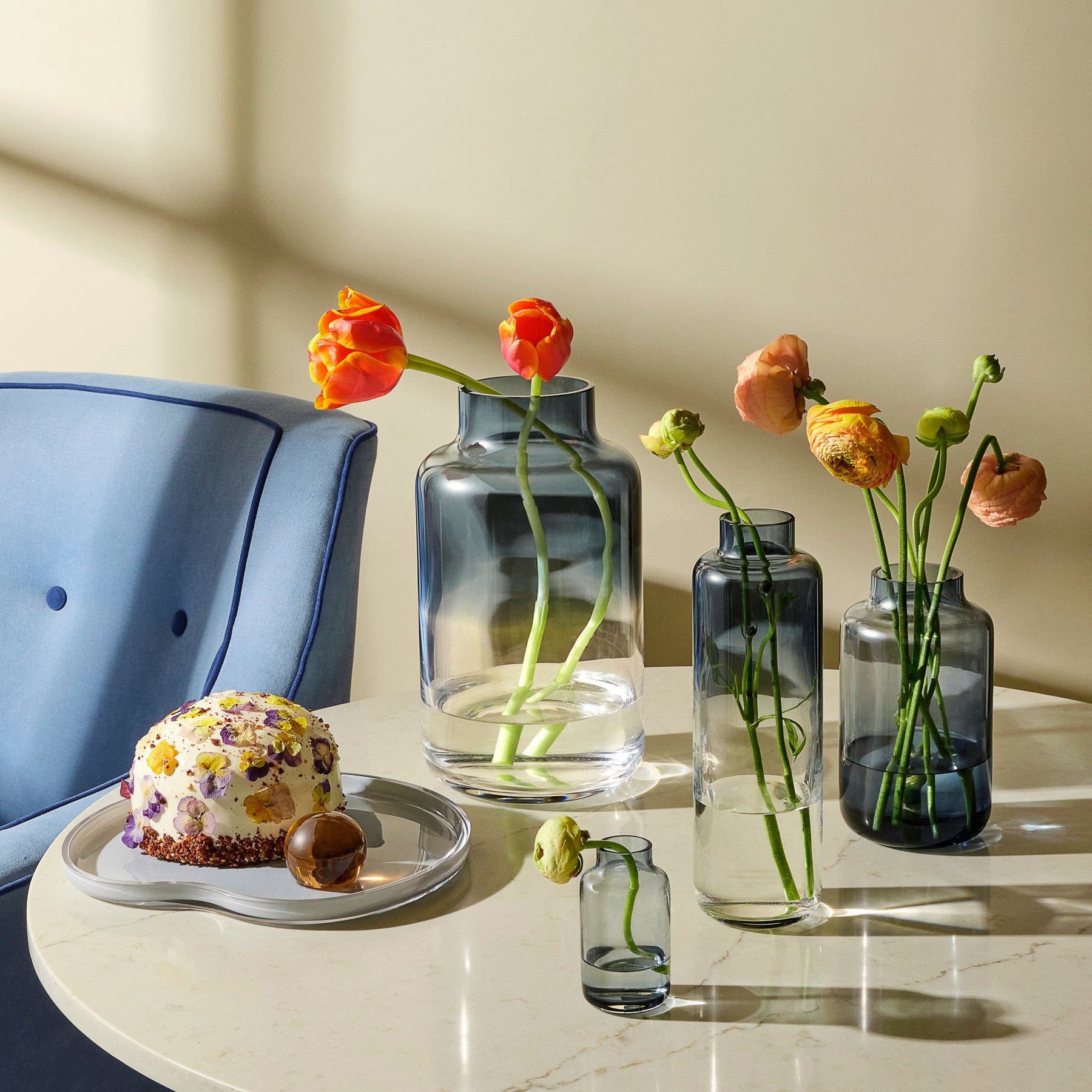Magnolia glass vases arranged beautifully with a modern ceramic serving plate on a minimalist surface.