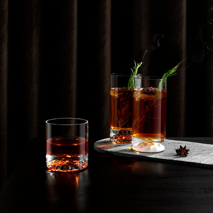A modern crystal tumbler filled with whisky and ice, showcasing the exceptional clarity of the glass.