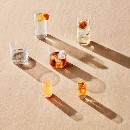 Contemporary minimalist glassware display showing clear tall tumblers on a neutral surface.