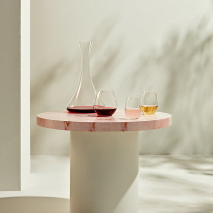 Close-up of a hand holding the refined NUDE Glass Pure Sweets & Spirits glass filled with a light digestif.