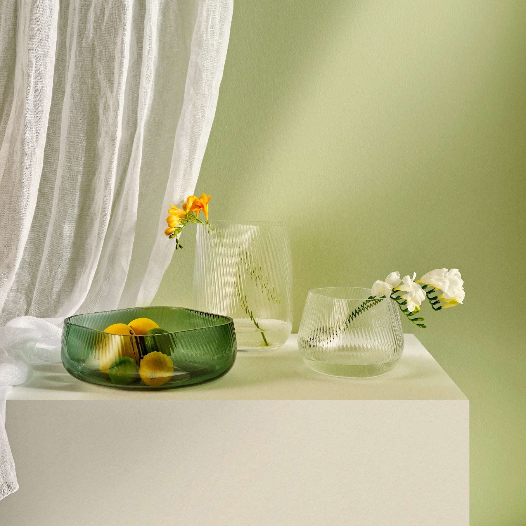 Stylized interior display of a modern NUDE Glass Opti crystal vase with single botanical branches