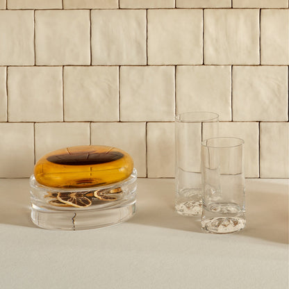 Detailed close-up of a NUDE Glass Club highball glass with an elegant beverage, showcasing modern barware styling.