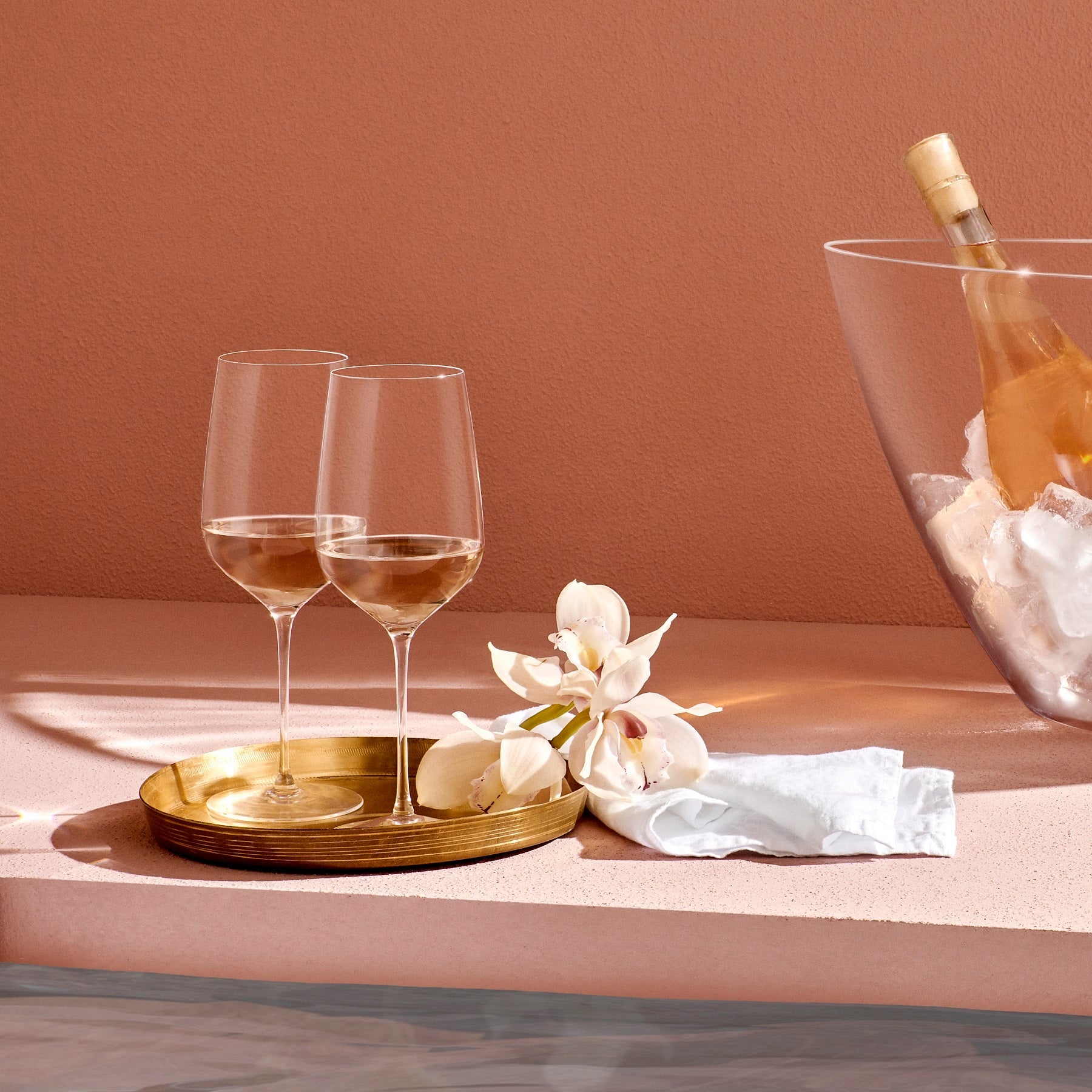 Atmospheric luxury dining table set with modern crystal stemware and minimal dinnerware.