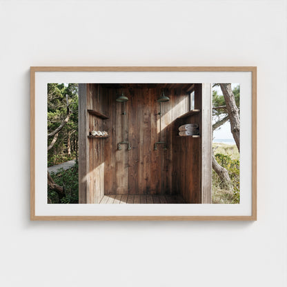 Pines Outdoor Shower framed art print in a 36x24 natural wood landscape frame hanging above a console.