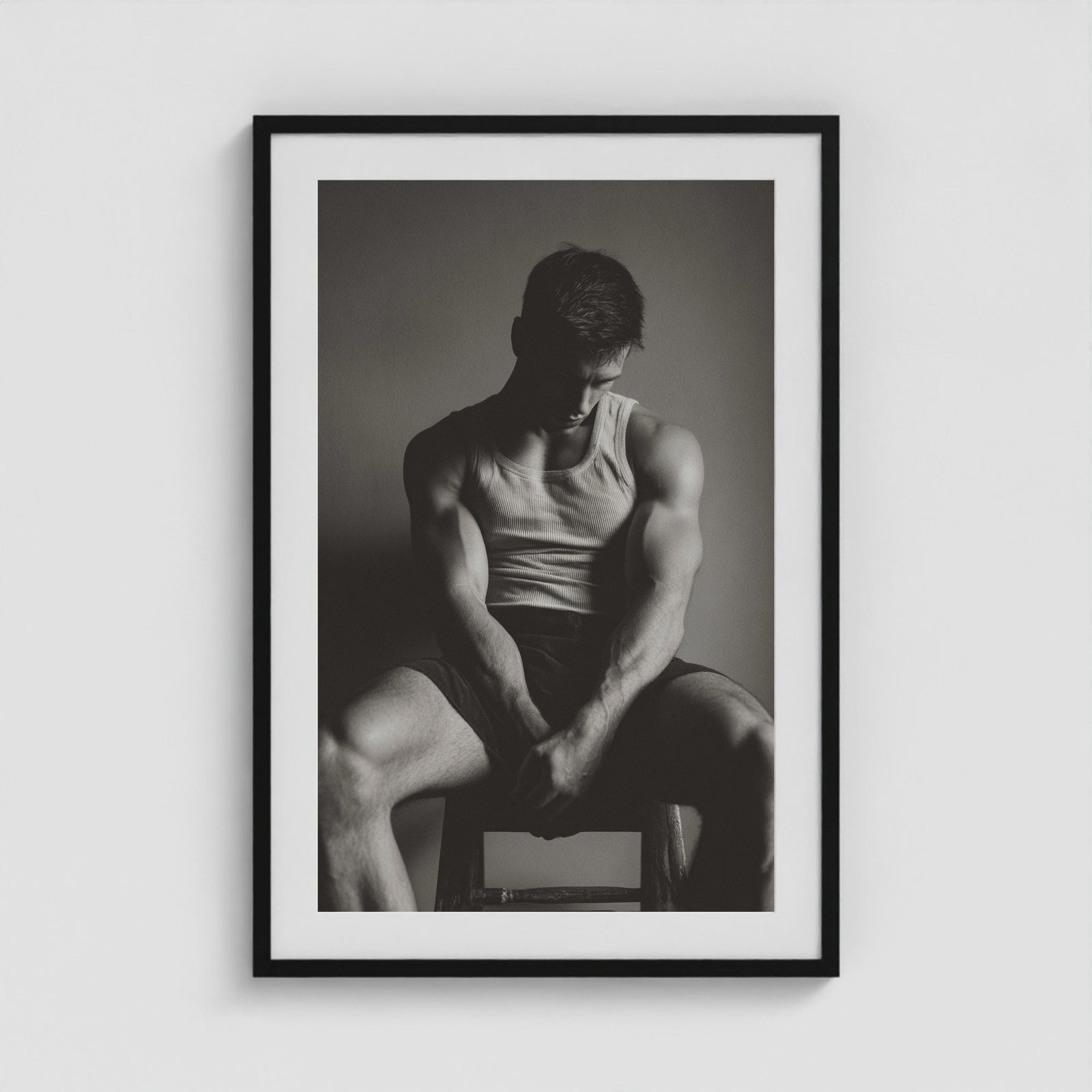 Seated male figure in denim portrait, framed in a twenty-four by thirty-six black box frame.