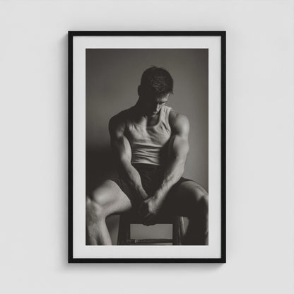 Seated male figure in denim portrait, framed in a twenty-four by thirty-six black box frame.