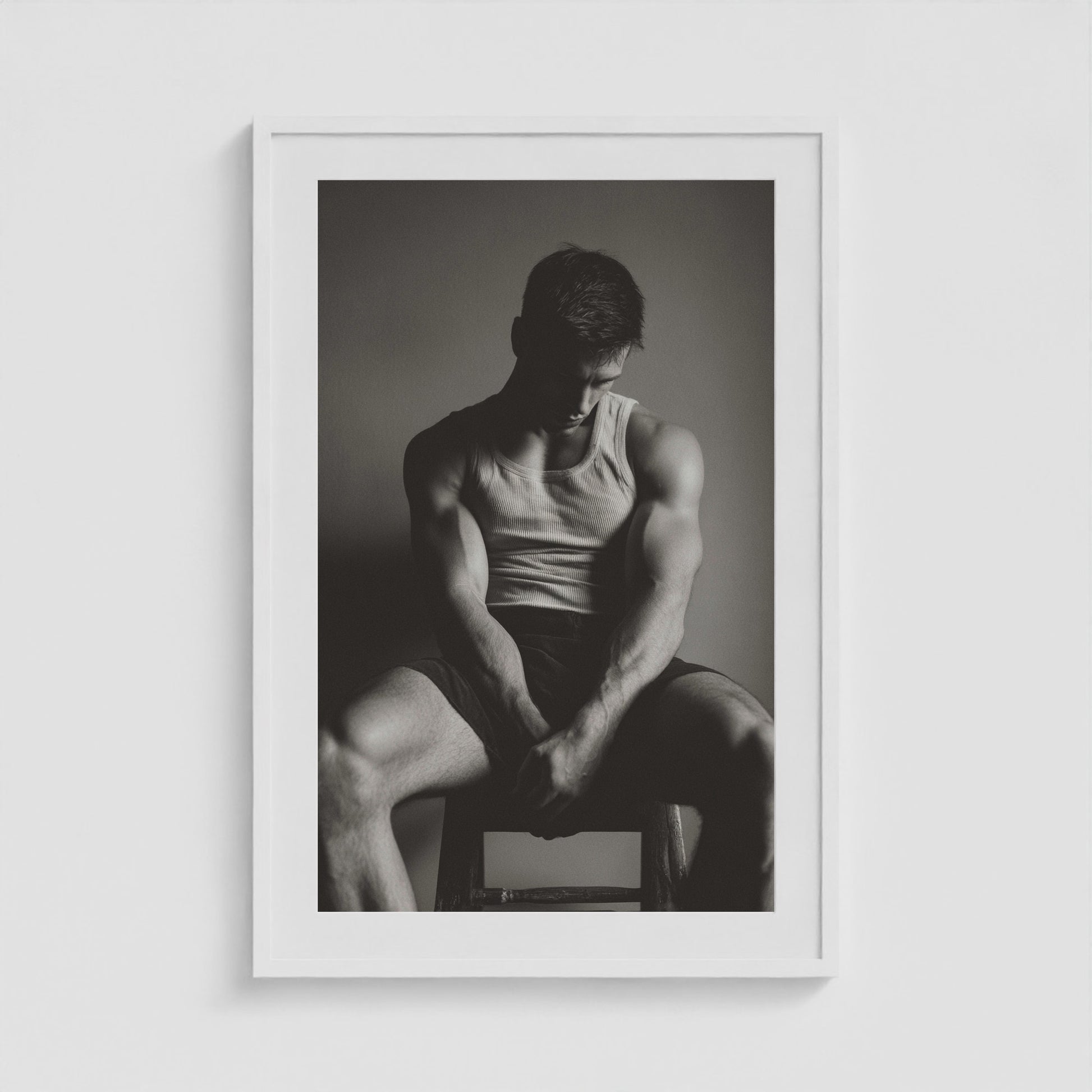 Seated male figure in denim portrait, framed in a twenty-four by thirty-six white box frame.