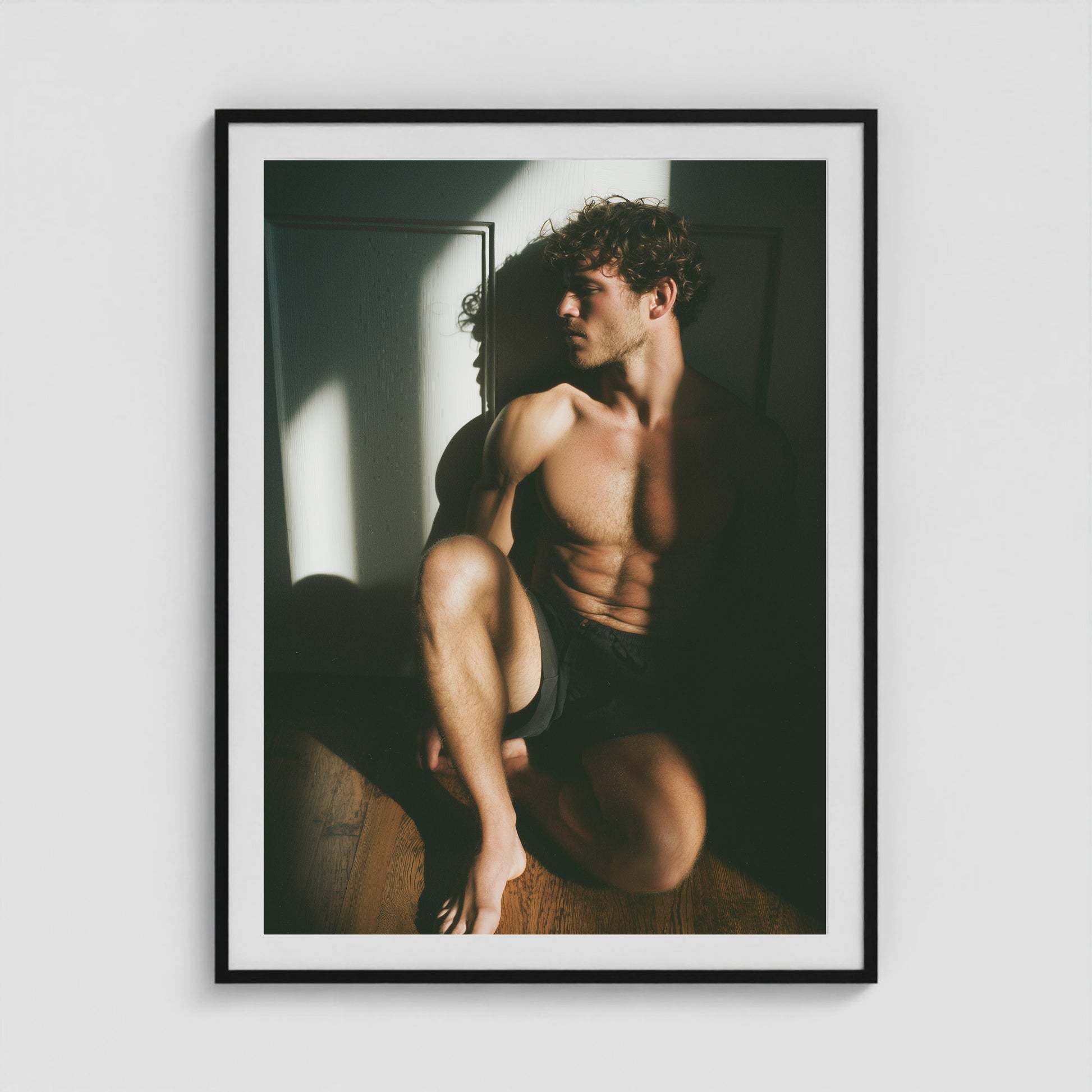 Male figure study in sunlit shadow art print in a 36x48 black portrait box frame.