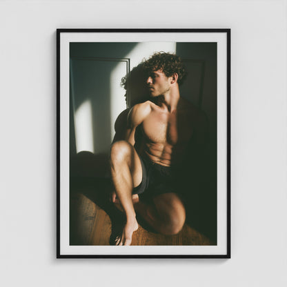 Male figure study in sunlit shadow art print in a 36x48 black portrait box frame.