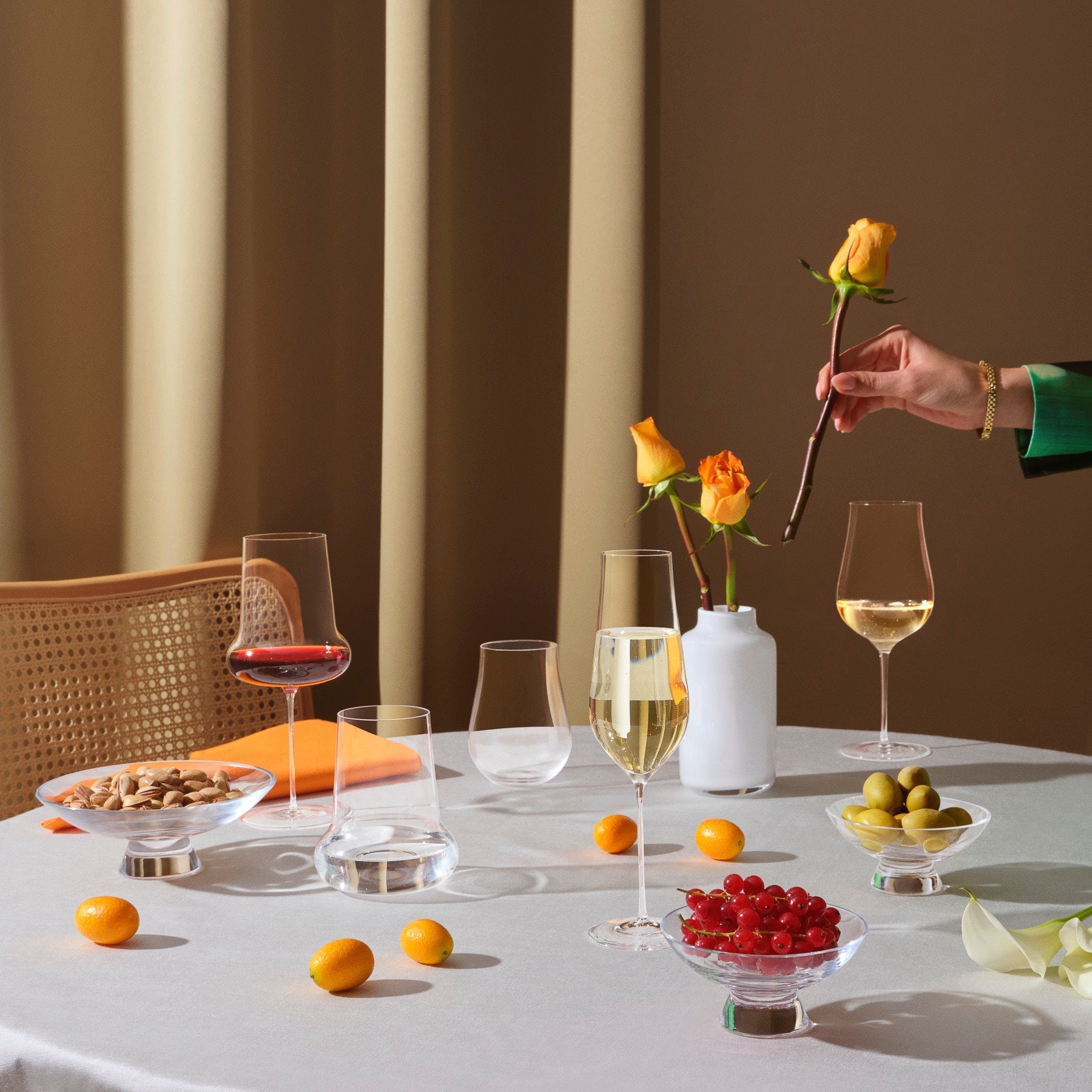 An elegant table setting featuring fine crystal glassware, fresh florals, and modern tableware.