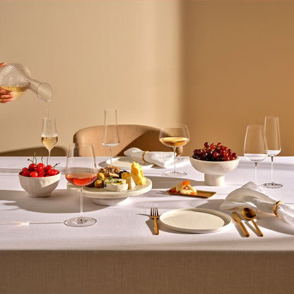 An assortment of NUDE Stem Zero crystal wine glasses, champagnes, and decanters on display.