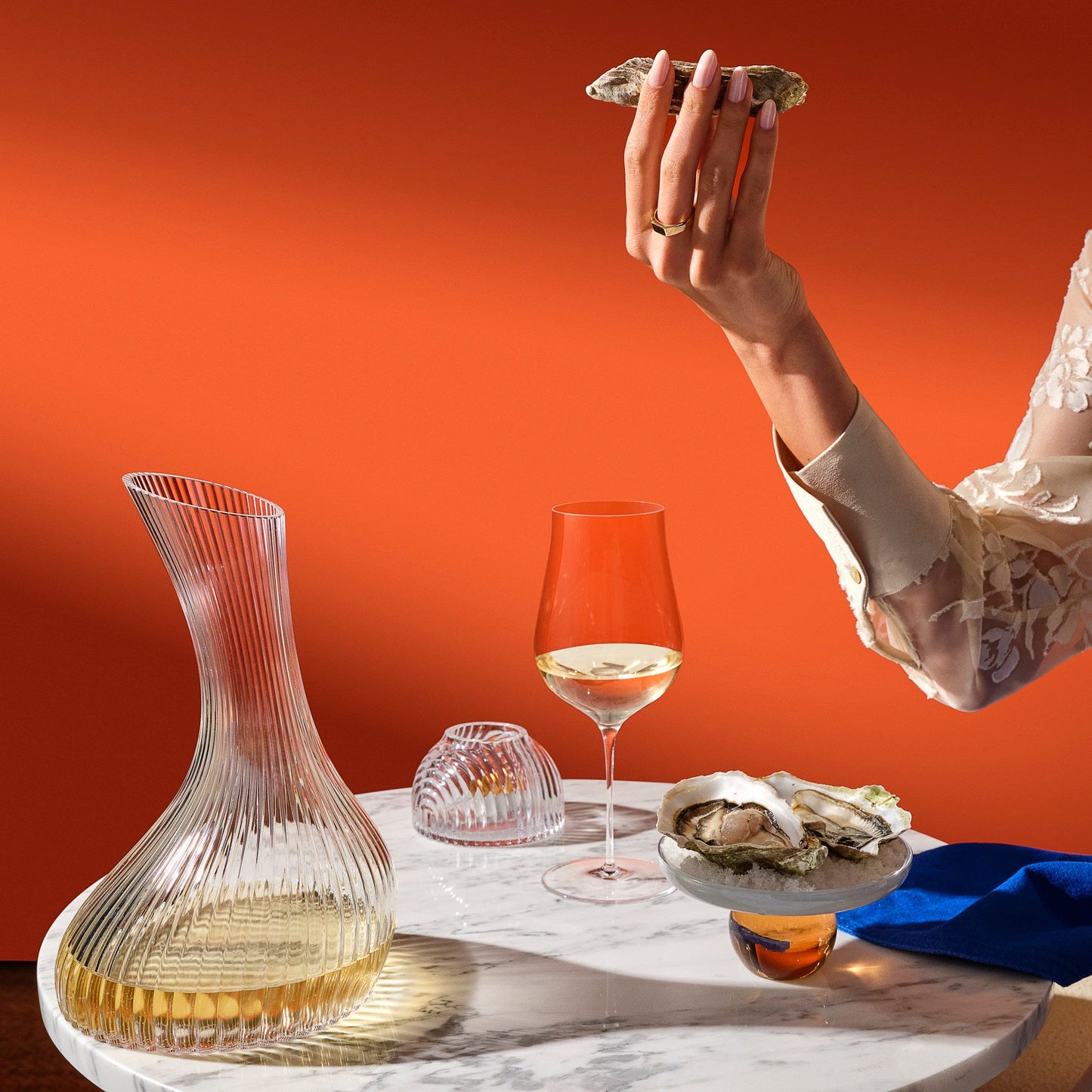 Elegant dining setup with a crystal carafe, modern votive holder, and Ghost Zero tulip glasses on a clean surface.