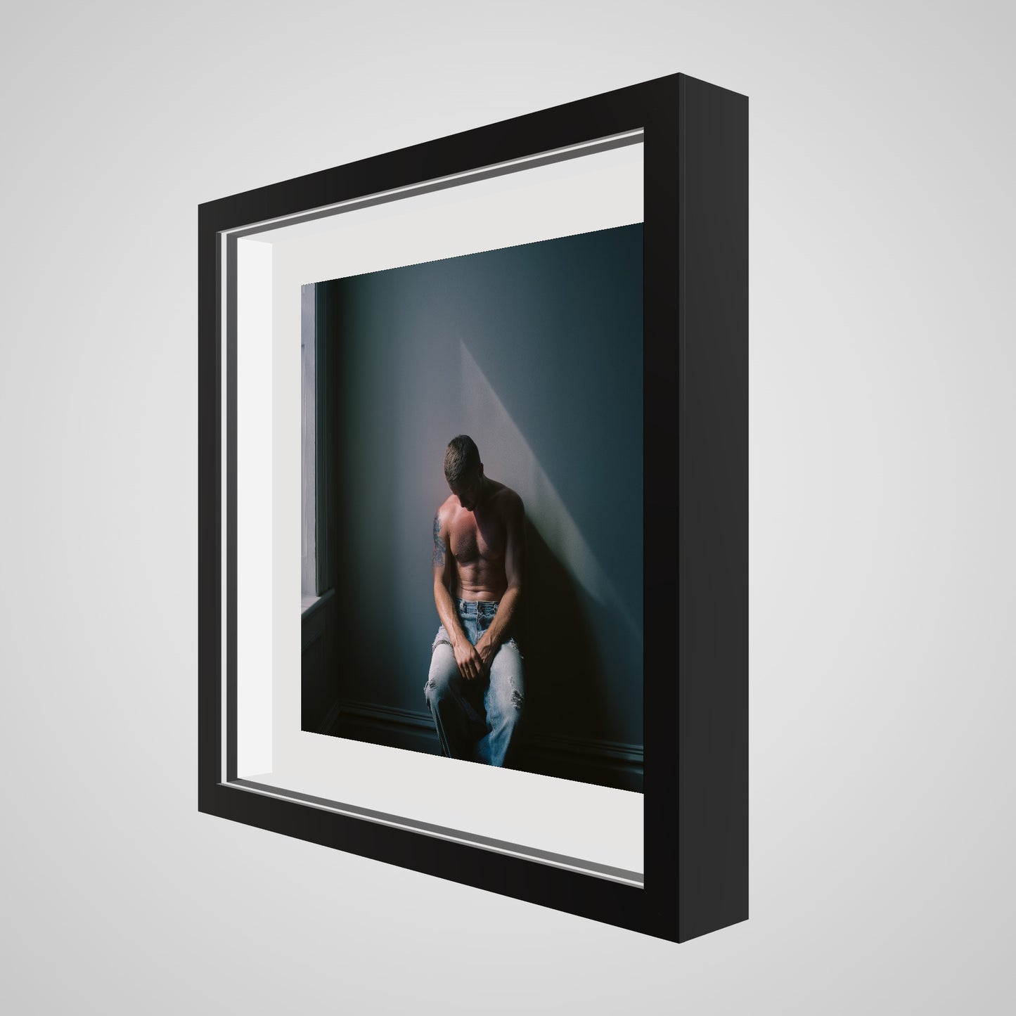 Angled view of Contemplative Male Portrait Art Print in a 16x16 deep black square spacer frame