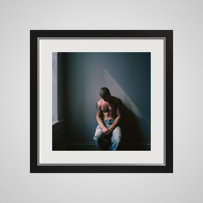 Front view of Contemplative Male Portrait Art Print in a 16x16 deep black square spacer frame