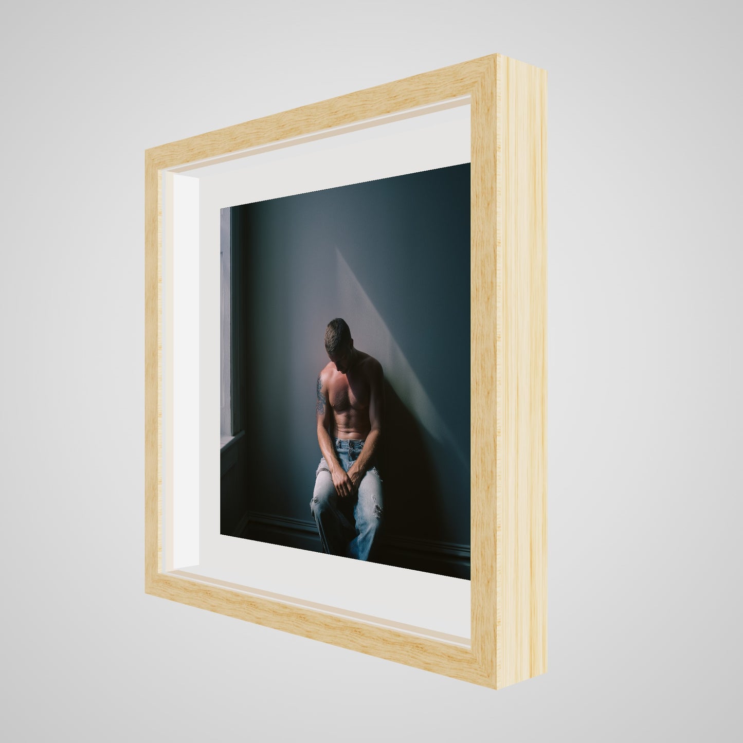 Angled view of Contemplative Male Portrait Art Print in a 16x16 deep natural square spacer frame