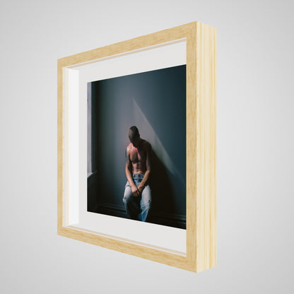 Angled view of Contemplative Male Portrait Art Print in a 16x16 deep natural square spacer frame