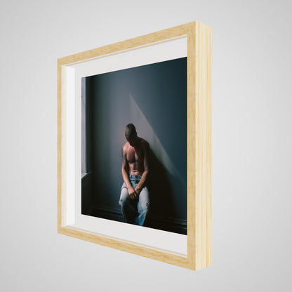 Angled view of Contemplative Male Portrait Art Print in a 20x20 deep natural square spacer frame