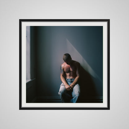 Front view of Contemplative Male Portrait Art Print in a 36x36 deep black square spacer frame