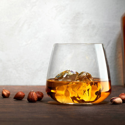 A lifestyle setting showing a Mirage crystal tumbler resting on a polished wooden surface.