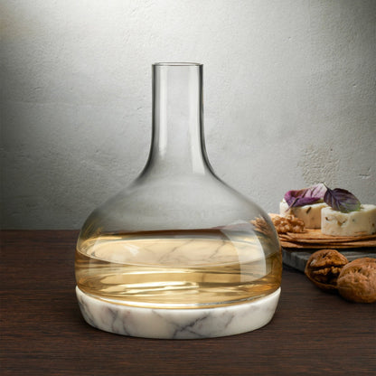 A hand pouring red wine from the NUDE Chill crystal carafe at a beautifully set dining table.