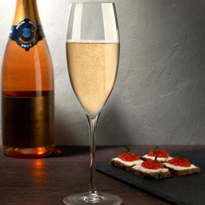 Two Dimple crystal champagne glasses arranged on an elegant tabletop, showcasing contemporary barware for luxury entertaining.