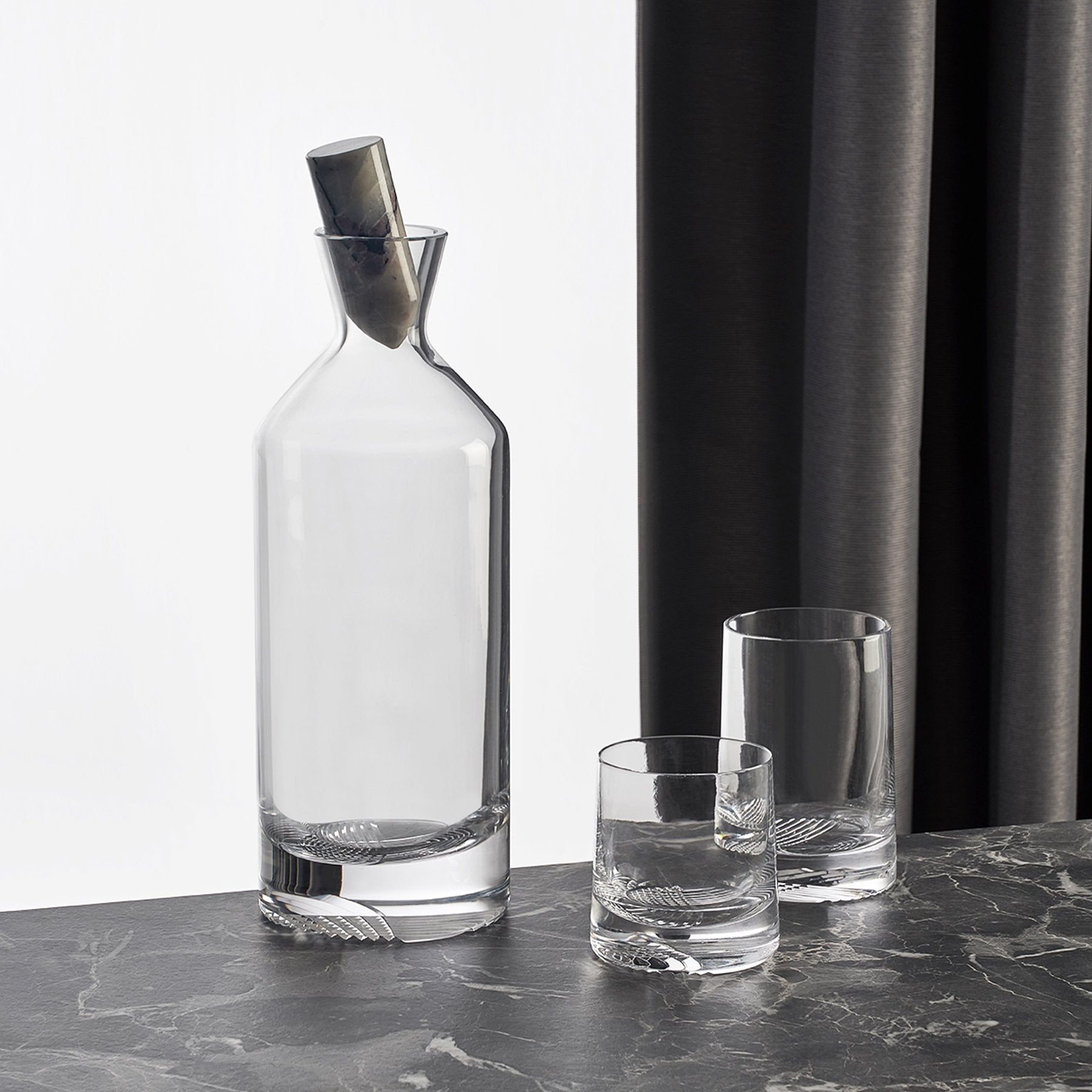Curated barware set showcasing the Alba tall whisky bottle alongside companion crystal glasses on a dark surface.