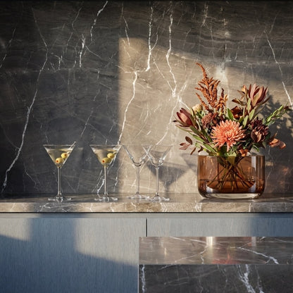 The NUDE Blade Wide Crystal Vase in green, showing its sharp geometric lines and smooth curves designed by Pentagon Design.
