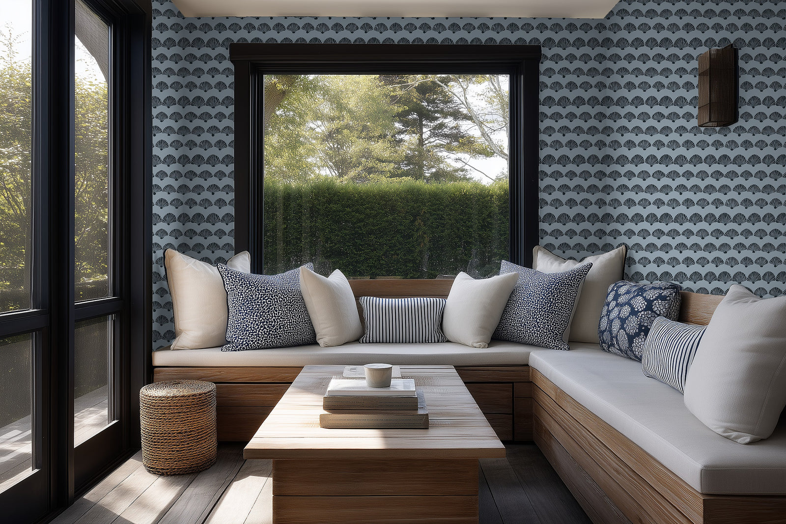 A sunlit sunroom with blue wave-patterned scallop wallpaper adding a fresh coastal feel.