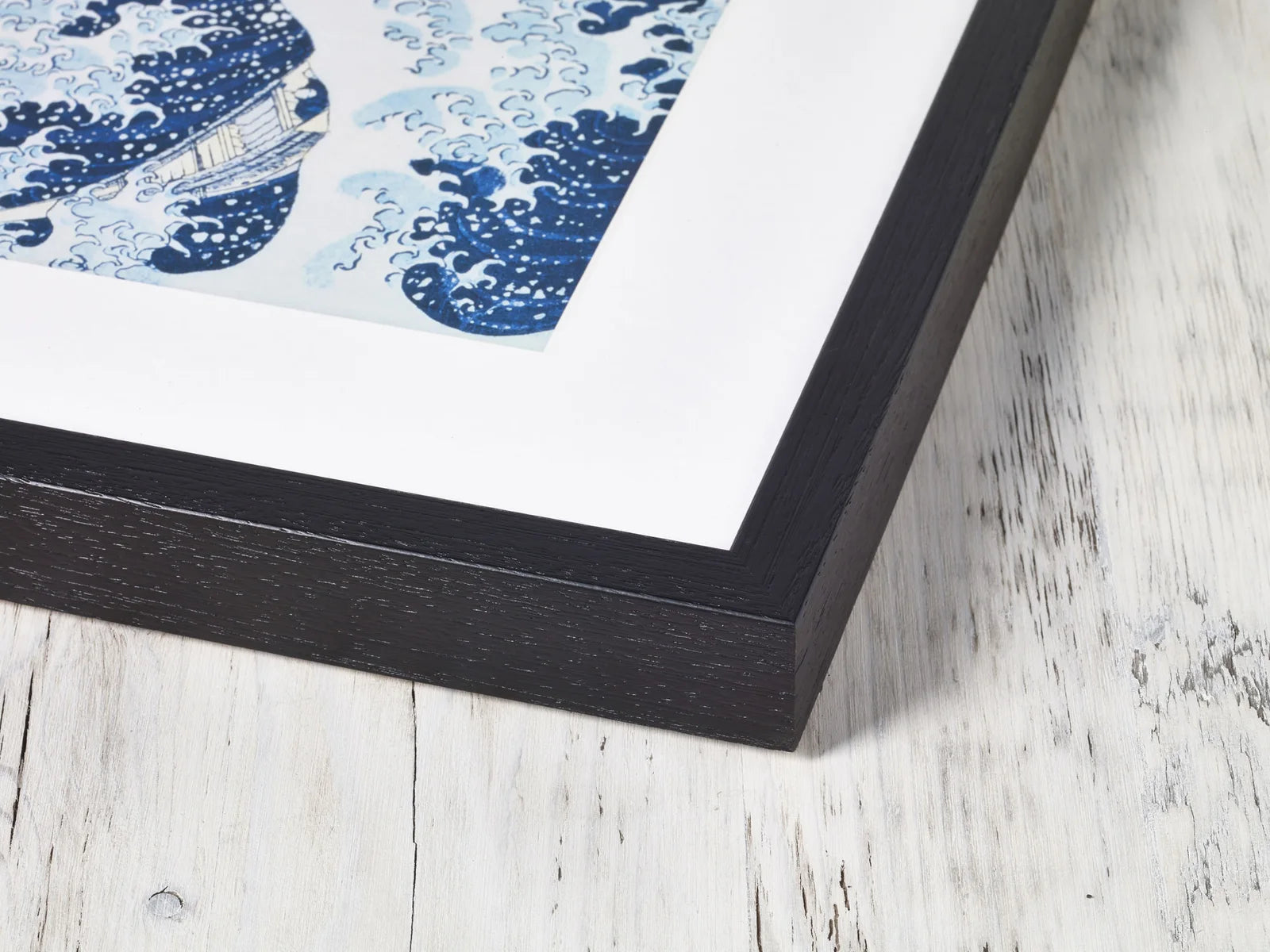 Close view of a black box-frame corner and mat